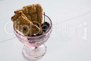 Granola bar and dark cherry fruit in glass