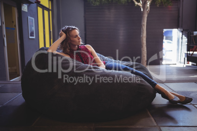 Young female customer relaxing on bean bag
