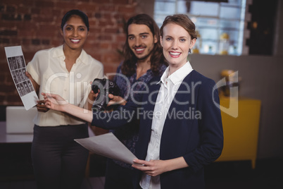 Portrait of smiling young creative team discussing collage