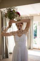 Angry bride throwing bouquet at home