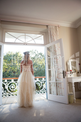 Rear view of bride standing at doorway at home