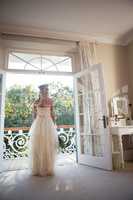 Rear view of bride standing at doorway at home