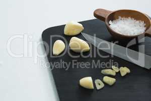 Chopped garlic with bowl of sea salt and knife