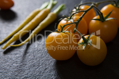 Carrots and tomatoes on black background