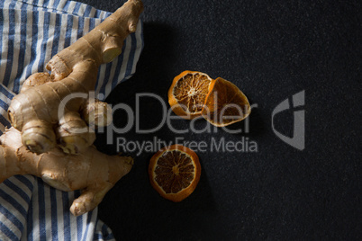 Ginger and dried orange sliced on black background