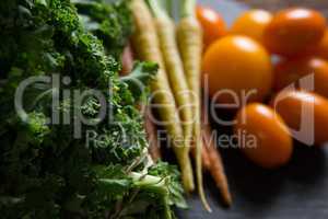 Mustard greens, carrots and tomatoes on tray