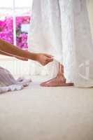 Bridesmaid adjusting bride dress in fitting room