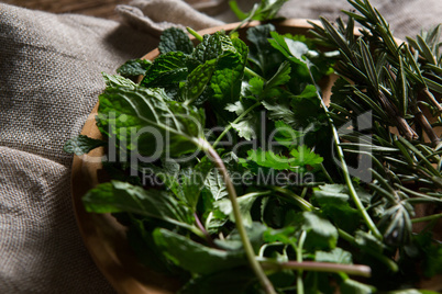 Fresh herbs in wooden plate