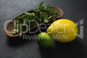 Mint leaf and sweet limes on black background