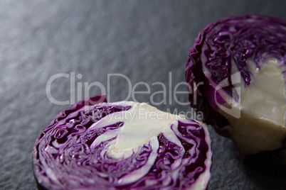 Halved red cabbage on black background