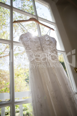 Low angle view of wedding dress hanging on window