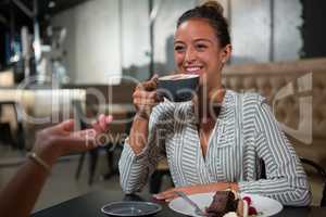 Beautiful woman interacting while having coffee