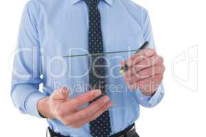 Mid section of businessman writing on glass interface