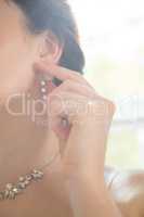 Cropped image of woman wearing diamond earring by window