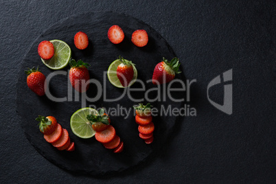 Sliced strawberries and lemon on round tray