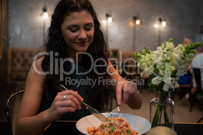 Beautiful woman having food at table