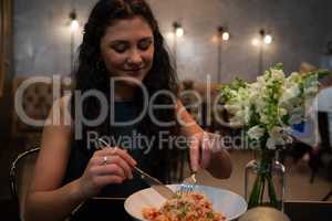 Beautiful woman having food at table