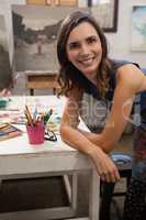Smiling woman leaning at table in drawing class