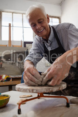 Smiling senior man molding clay
