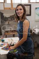 Smiling woman sitting at table in drawing class