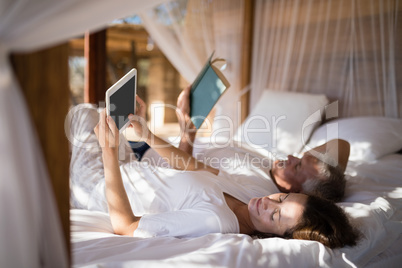 Couple relaxing on canopy bed
