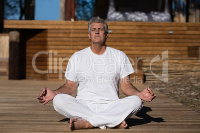 Man practicing yoga on wooden plank