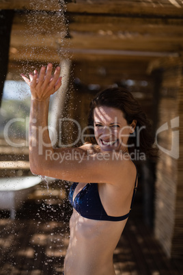 Smiling woman taking bath in shower