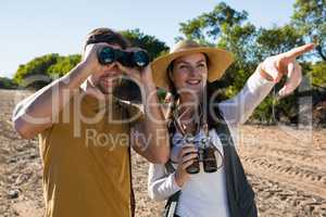 Couple with binoculars at forest
