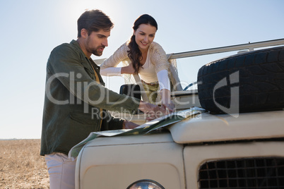 Couple pointing at map in forest