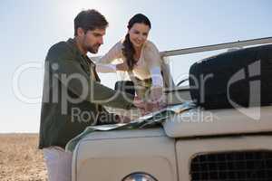 Couple pointing at map in forest