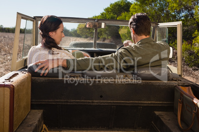 Rear view of man with woman driving off road vehicle