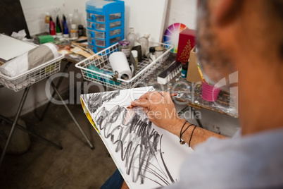 Man sketching in drawing book