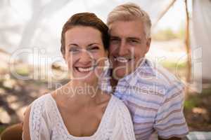 Portrait of happy couple sitting in cottage