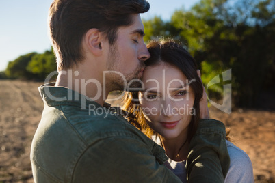 Man kissing woman on field