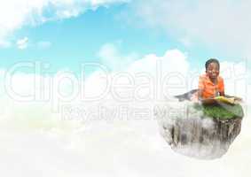 Young boy on floating rock platform  in sky reading book