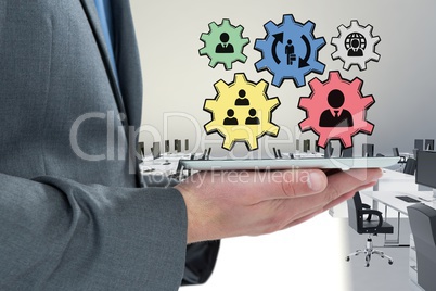 Business man interacting with people in cogs graphics against office background