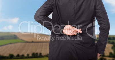 Businessman in nature countryside crossing fingers