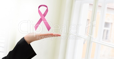 Open hand with pink ribbon for breast cancer awareness