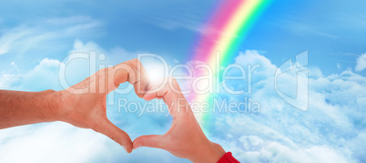 Composite image of couple making heart shape with hands