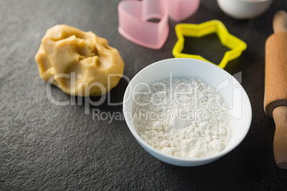 High angle view of dough and flour with pastry cutters