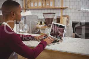 Owner using laptop in cafe