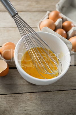 High angle view of eggs in bowl and carton