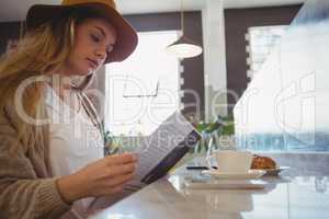 Woman reading menu in cafe