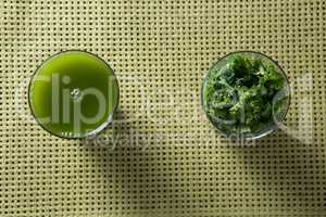 Fresh kale juice and leaves in glass on table
