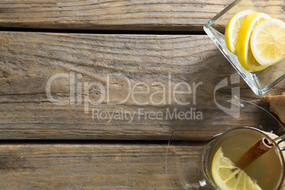 Overhead view of ginger tea with lemons on table