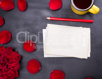 stack of paper postcards and a yellow cup