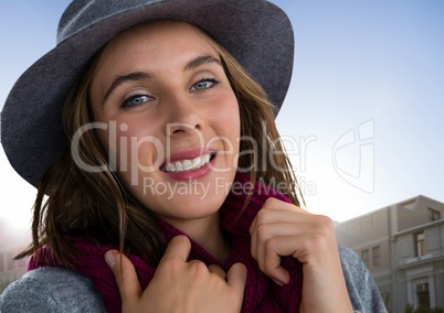 Woman wearing scarf and hat with building and sky