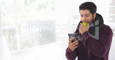 Man in Autumn with apple and phone at bright home