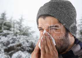 Man blowing his nose in snow forest