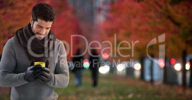 Man in Autumn with phone in city park